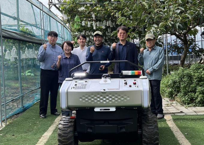 김운학 산업지원본부장(오른쪽 두번째)이 관내 농가에 운반로봇을 보급하고 기념촬영을 하고 있다.