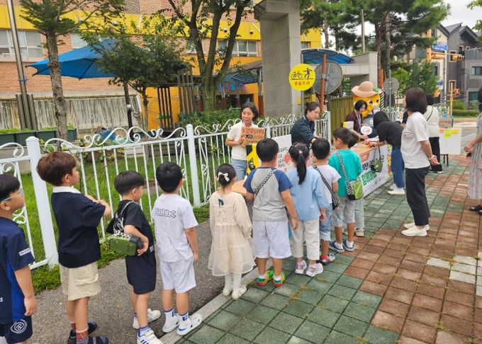 화성특례시가 18일 향남유치원 앞에서 어린이들과 학부모들을 대상으로 환경친화적 저탄소 식문화 캠페인을 운영하고 있다