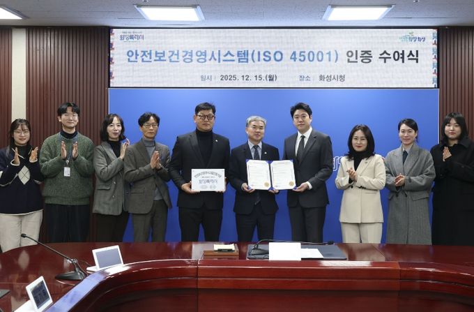 정구원 화성특례시 제1부시장 및 안상현 ISO 45001 선임 심사원 등 관계자가 안전보건경영시스템 인증식에서 기념 촬영을 하고 있다